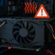 Überhitzte Grafikkarte mit Warnsymbol im geöffneten PC-Gehäuse